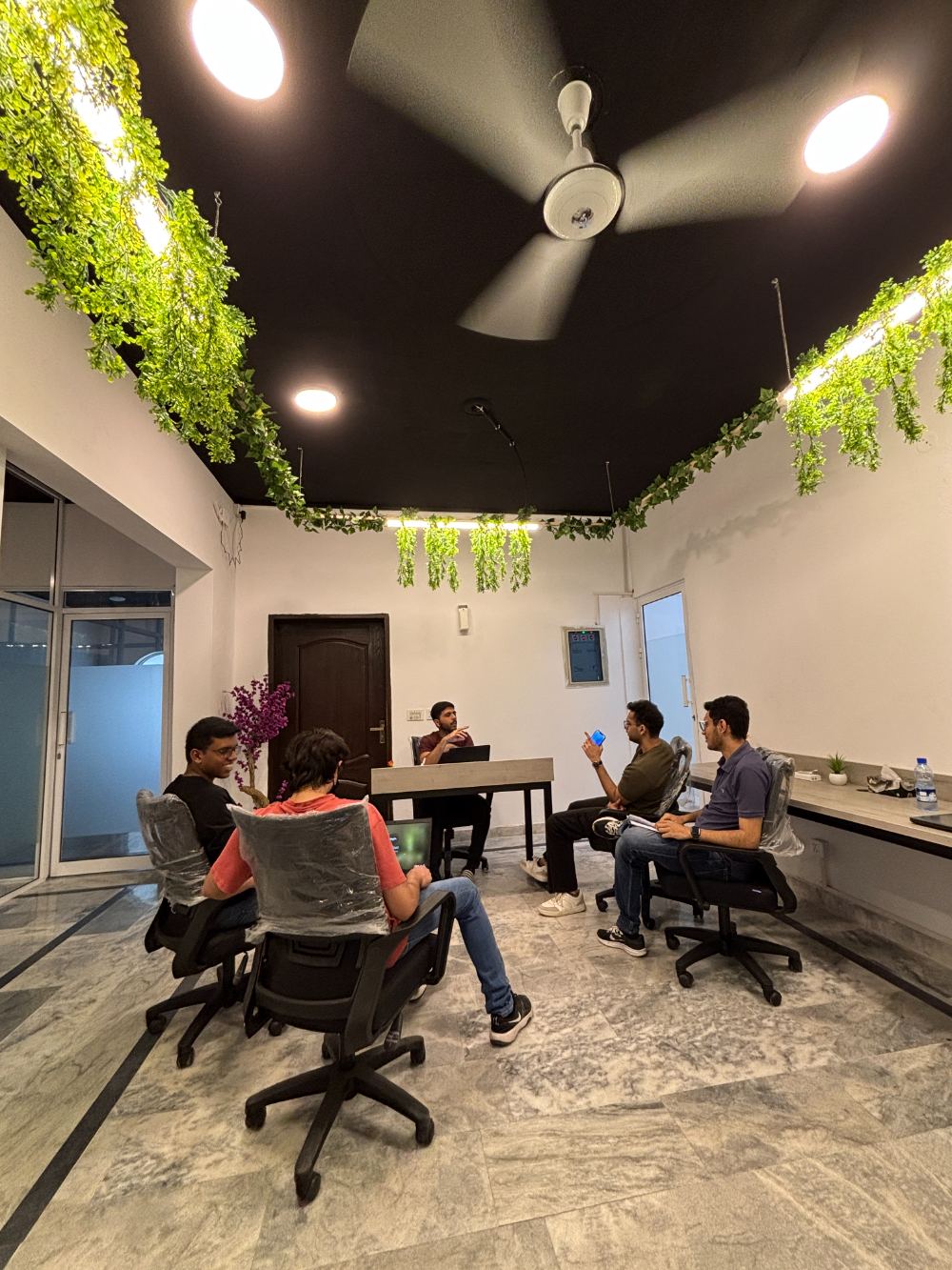 Team discussion in the WorkHive lounge under hanging plants