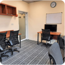 Private office with ergonomic chairs and wall-mounted screen at WorkHive